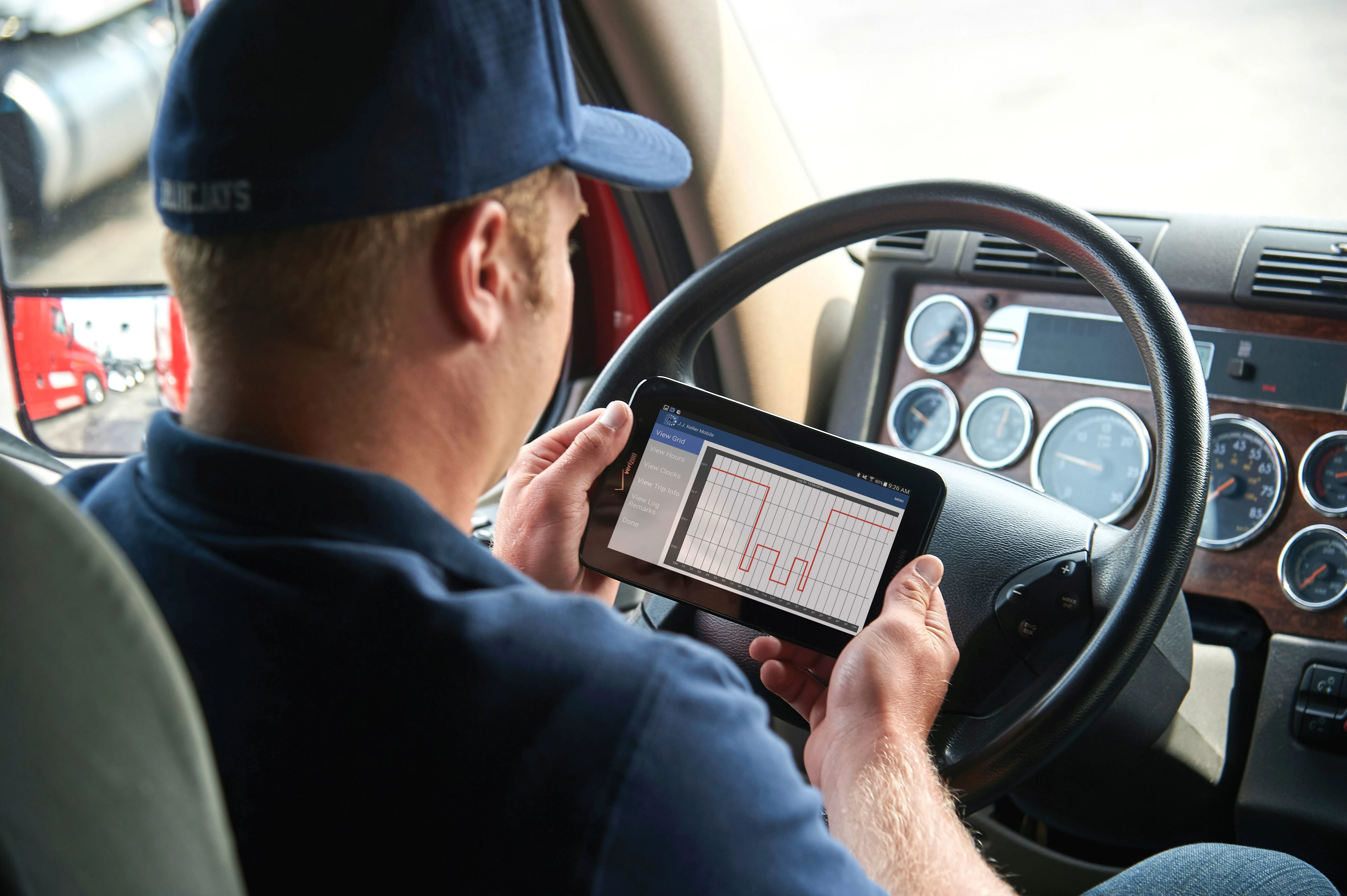 Driver reviewing ELD logs on a tablet inside a truck