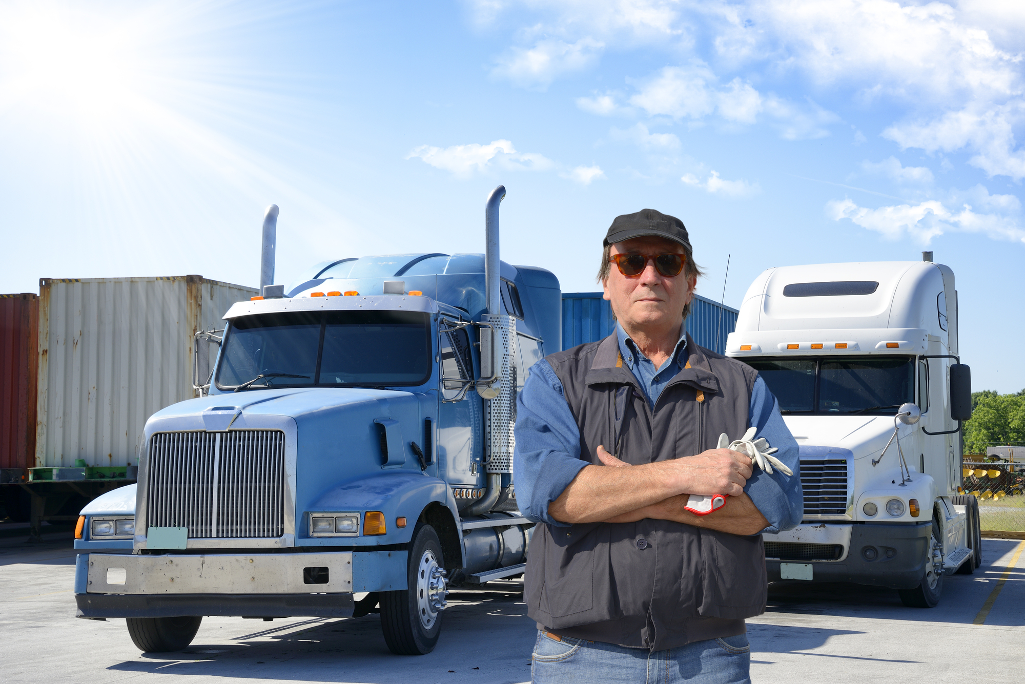USA truck driver standing with commercial trucks